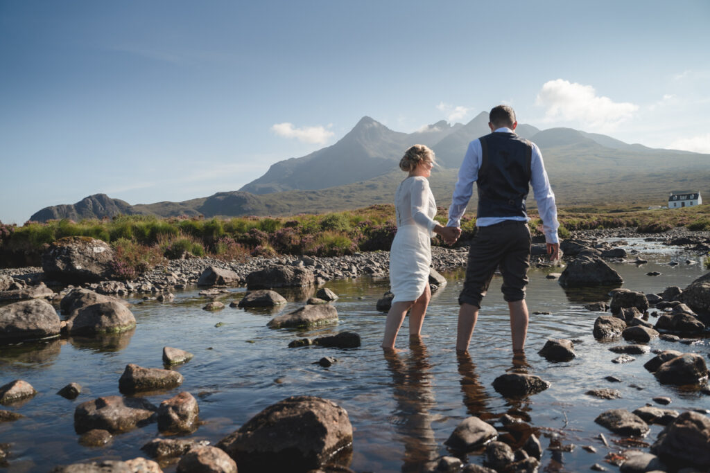 Cpouple paddling ina. stream on the Isle of Skye during their elopement