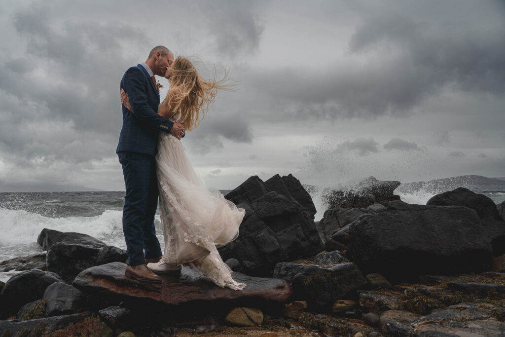 Couple embrace in crashing waves on thei Isle of Skye elopement