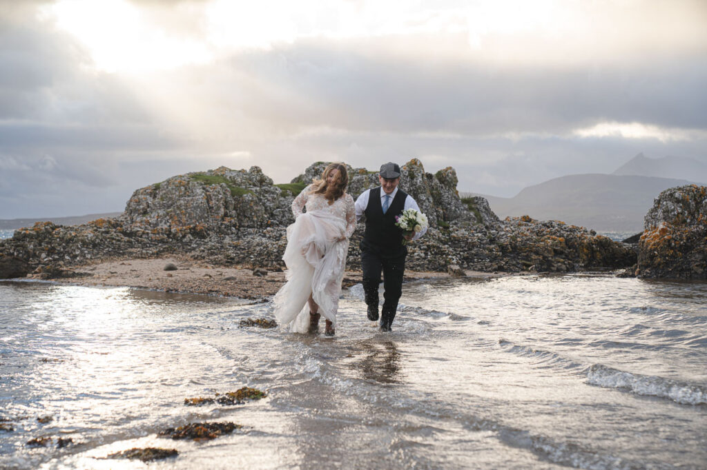 Isle of skye elopement photographer captures bride and groom in the sea at elopement wedding