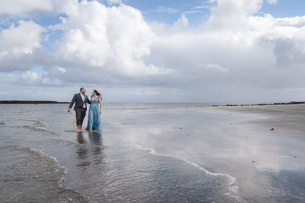 couple in the sea in smart clothes on their isle of skye vacation photoshoot