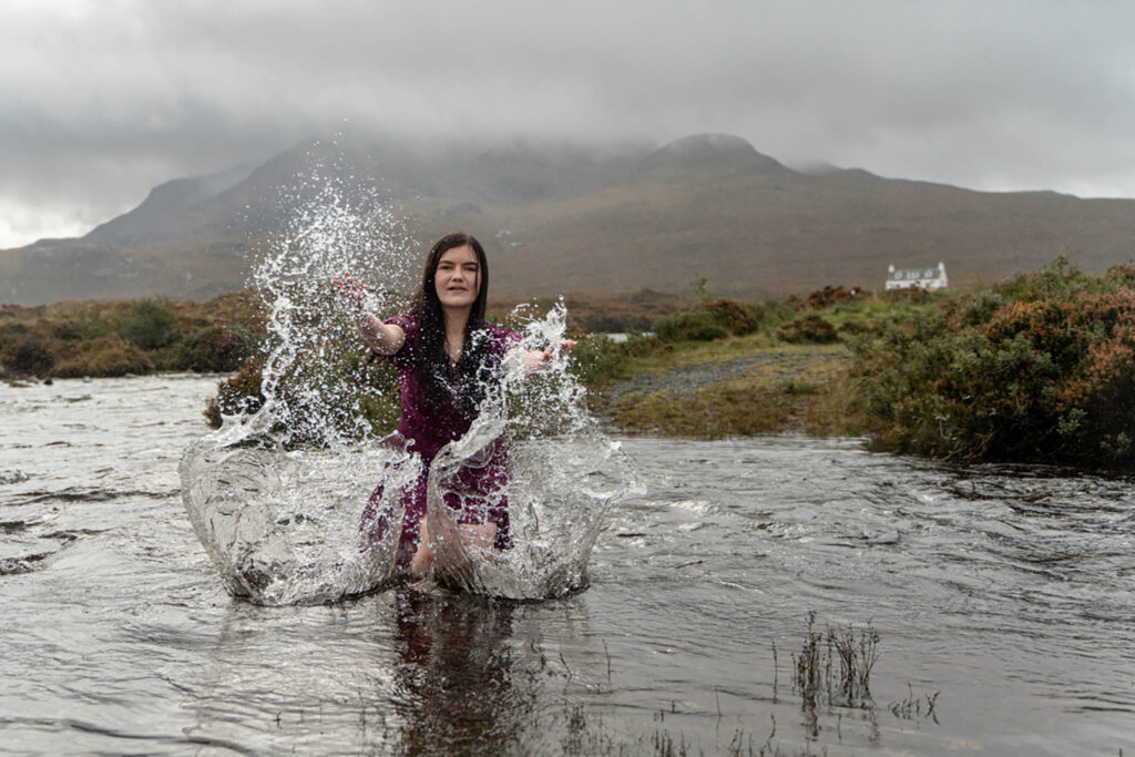 teenage girl splashing in the water at her senior photo shoot on skye, by vacation family photographer on the Isle of Skye Penny Hardie