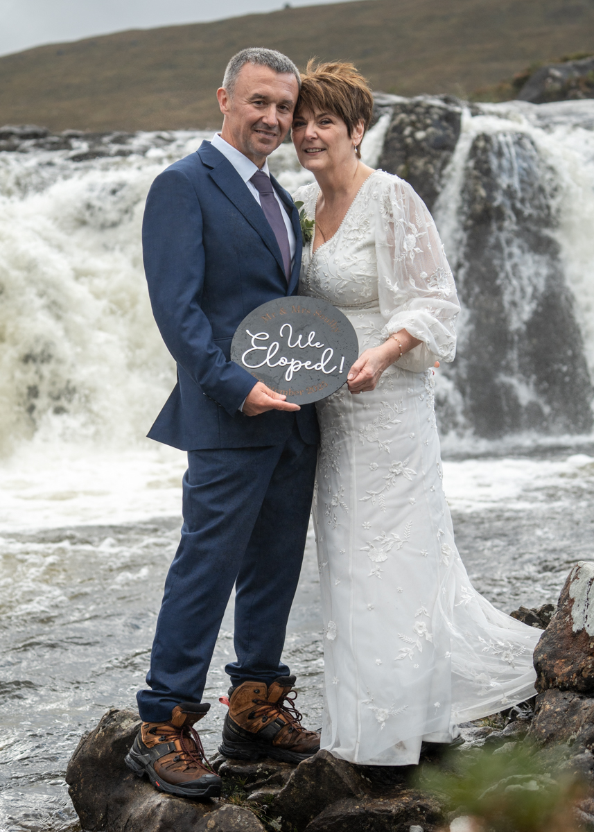 we-eloped-to-the-isle-of-skye Couple wth sign reading "WE ELOPED" on the Isle of Skye