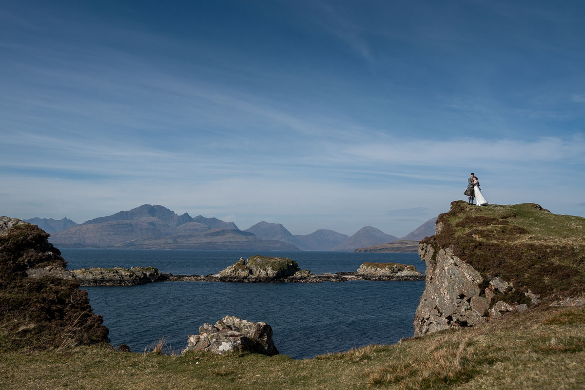 Eloping couple embracing with panoramic mountain views at Sligachan, photographed by Penny Hardie.