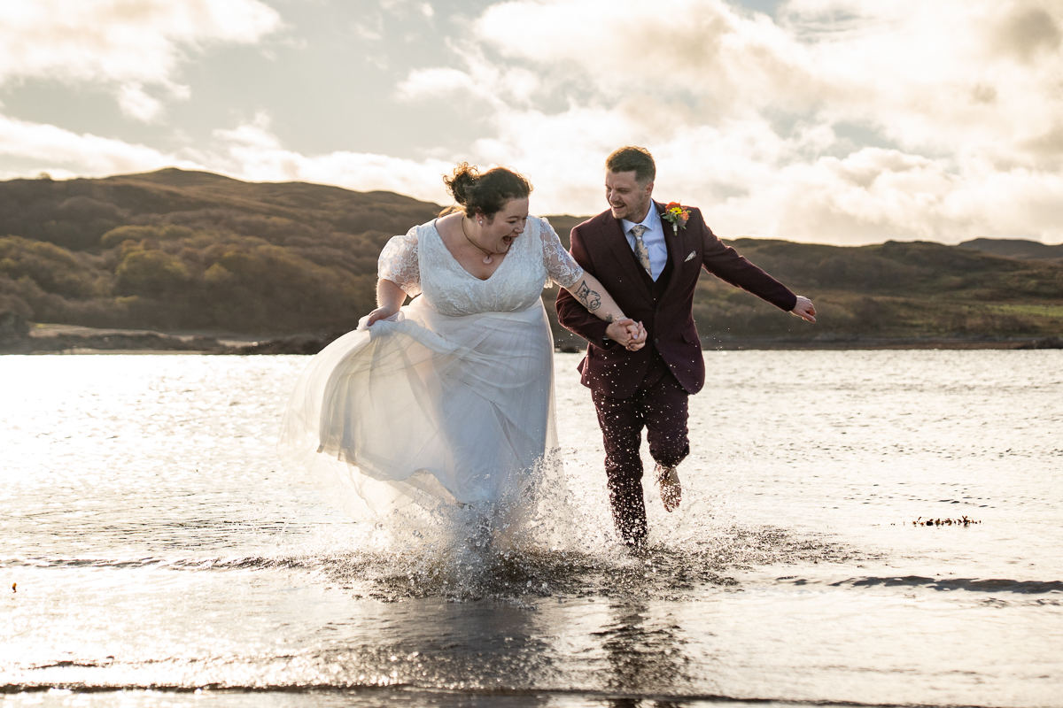 couple paddling in the cold water on the Isle of Skye in Winter